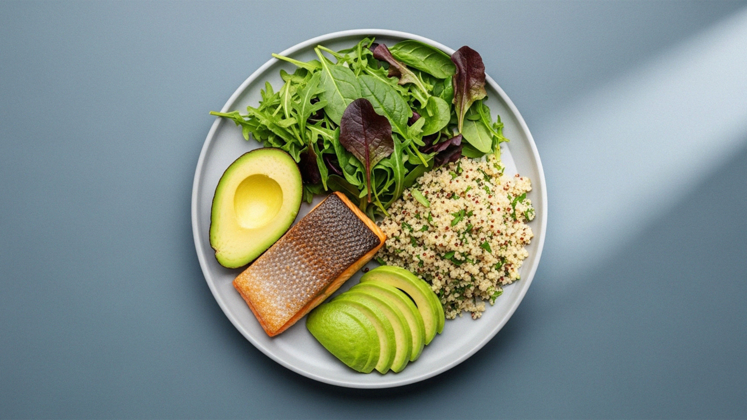 Assiette équilibrée avec saumon, quinoa, légumes verts et avocat