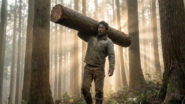 自然の中で重い荷物を運び、機能的な力を示す男性。