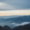 Man standing at sunrise on a mountain ridge during a solo trip
