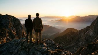 A father and son observing a mountain landscape, symbolizing guidance and the passing of a masculine legacy.