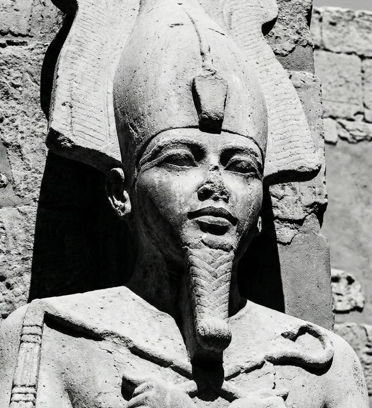 Escultura em pedra de uma divindade antiga representando força e potência masculina.