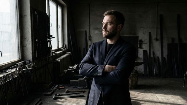 Un homme confiant debout avec une posture solide et un langage corporel ouvert.