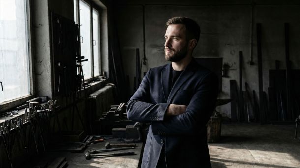 A confident man standing with strong posture and open body language.