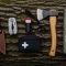 Flat-lay of essential survival tools on canvas: fixed blade, multi-tool, ferro rod, headlamp, water filter, first-aid, paracord, power bank, folding saw, space blanket.
